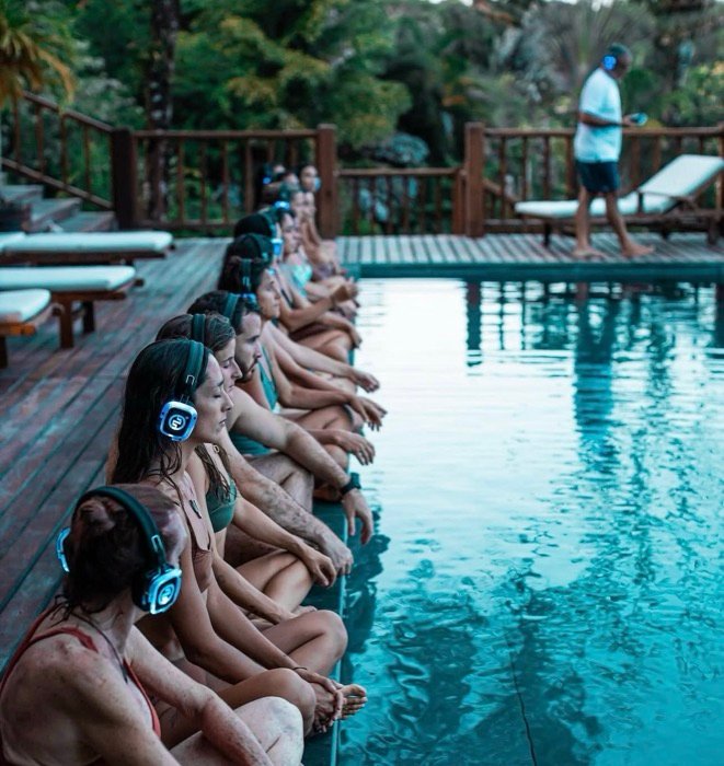 Meditación grupal junto a la piscina, retiro de bienestar